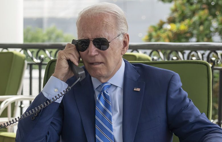 In this image provided by the White House, President Joe Biden speaks on the phone with White House chief of staff Ron Klain from the Truman Balcony, Monday, July 25, 2022, at the White House in Washington. (Adam Schultz/The White House via AP) DCJE307 DCJE307