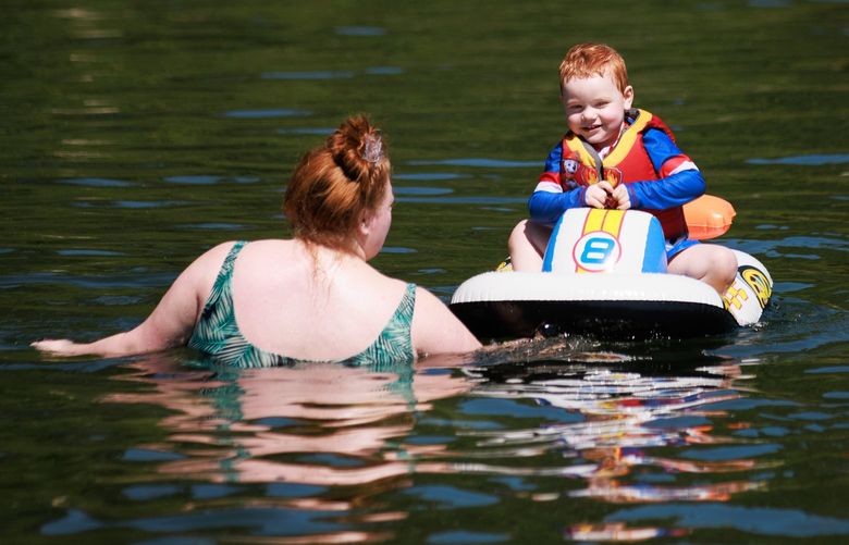 Shelby Dunham plays with her son Huck Hellwig, 2 1/2, in Lake Washington at Mount Baker Park Beach in Seattle Tuesday, July 26, 2022. The National Weather Service predicts temperatures to be in the 90s during the midweek, and issued a heat advisory until Friday. 
LO 221064