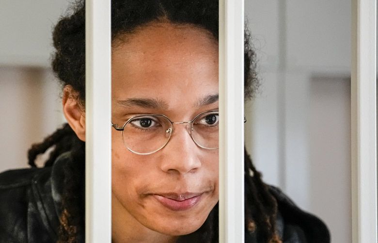 WNBA star and two-time Olympic gold medalist Brittney Griner speaks to her lawyers standing in a cage at a court room prior to a hearing, in Khimki just outside Moscow, Russia, Tuesday, July 26, 2022. American basketball star Brittney Griner returns Tuesday to a Russian courtroom for her drawn-out trial on drug charges that could bring her 10 years in prison of convicted. (AP Photo/Alexander Zemlianichenko, Pool) XAZ103 XAZ103