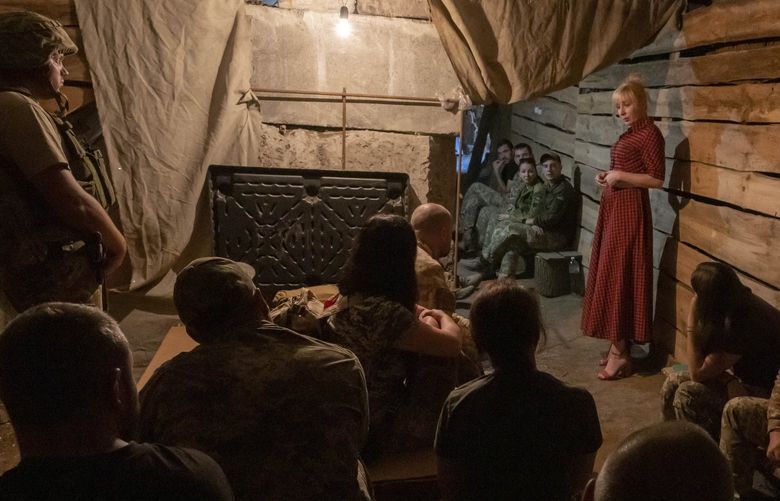 Medic volunteer Nataliia Voronkova, top right, gives a medical tactical training session to soldiers in a bomb shelter as air raid sirens go off, in Dobropillia, eastern Ukraine, Friday, July 22, 2022. Voronkova has dedicated her life to aid distribution and tactical medical training for soldiers and paramedics, working on front line of the Donetsk region since the war began in 2014. (AP Photo/Nariman El-Mofty) NM501 NM501