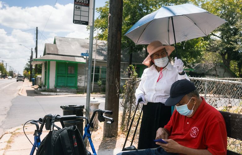 Amelia Castillo, 67, and Antonio Castillo, 66, wait at a bus stop with no roof in San Antonio, Texas, on Friday, July 22, 2022.  “Sometimes we have to wait for 40 to 50 minutes,” Amelia says. (Jordan Vonderhaar/The New York Times) XNYT61 XNYT61