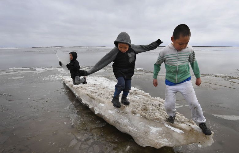 In this photo from April 18, 2019, schoolchildren play on melting ice at the Yup’ik Eskimo village of Napakiak on the Yukon Delta in Alaska. (MARK RALSTON/AFP via Getty Images/TNS) 54364889W 54364889W