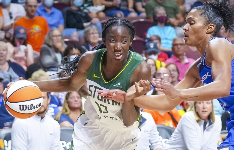 Seattle Storm center Ezi Magbegor (13) drives against Connecticut Sun forward Alyssa Thomas during the first half of a WNBA basketball game Thursday, July 28, 2022, in Uncasville, Conn. (AP Photo/Bryan Woolston) CTBW110