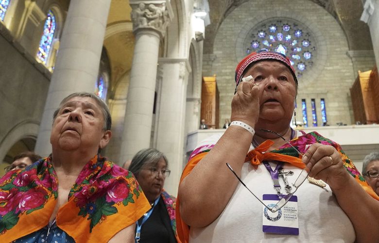 An Indigenous woman wipes a tear during a mass with Pope Francis at the Basilica of Sainte-Anne-de-BeauprÃ© in Ste-Anne-de-BeauprÃ©, Quebec , Thursday, July 28, 2022.  (Nathan Denette /The Canadian Press via AP) NSD117 NSD117