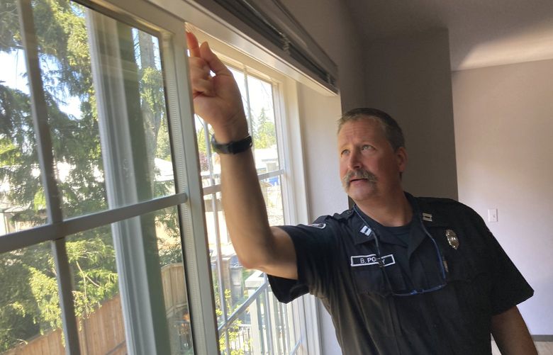 Everett Fire Department Capt. Berry Pomeroy inspects installation of a window stopper at Chelsea Nelson’s apartment in Everett, Wash., Thursday, July 21, 2022. As a heat wave looms in the Pacific Northwest, officials are warning about an old and stubborn foe: kids window falling from windows as the weather heats up. (AP Photo/Manuel Valdes) FX304 FX304