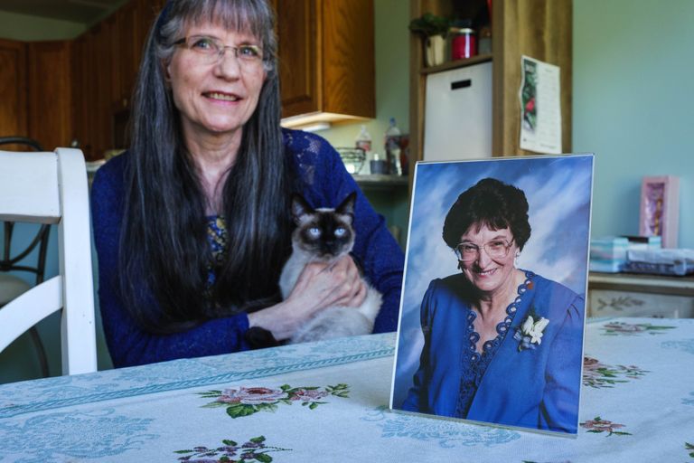 Woman poses with photo of her mother