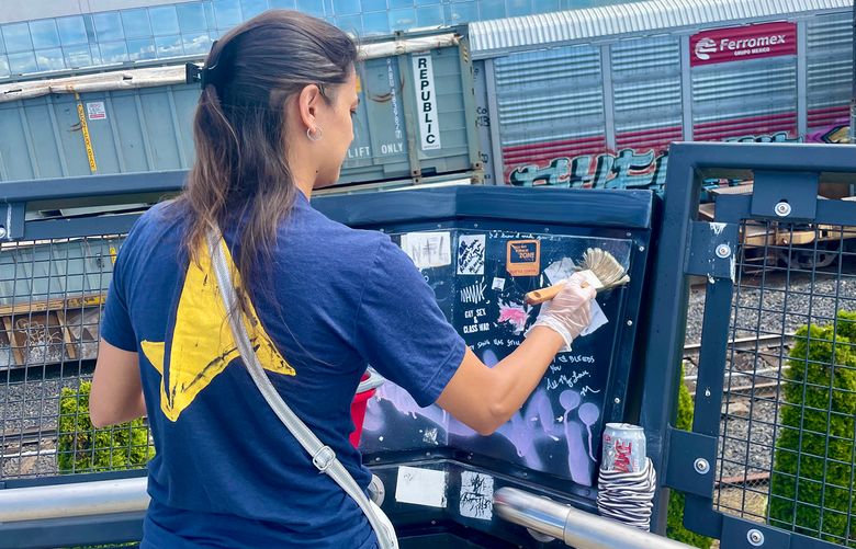 Thamiris Cortes De Aguiar, CityU Enactus President, painting over graffiti in downtown Seattle