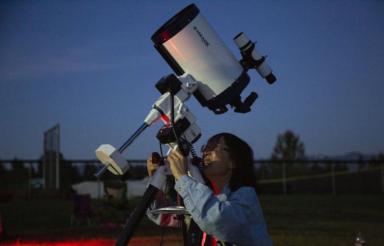 Auburn resident Trudy Kong works to focus one of the two large telescopes set up for the evening. Credit: Zach Powers