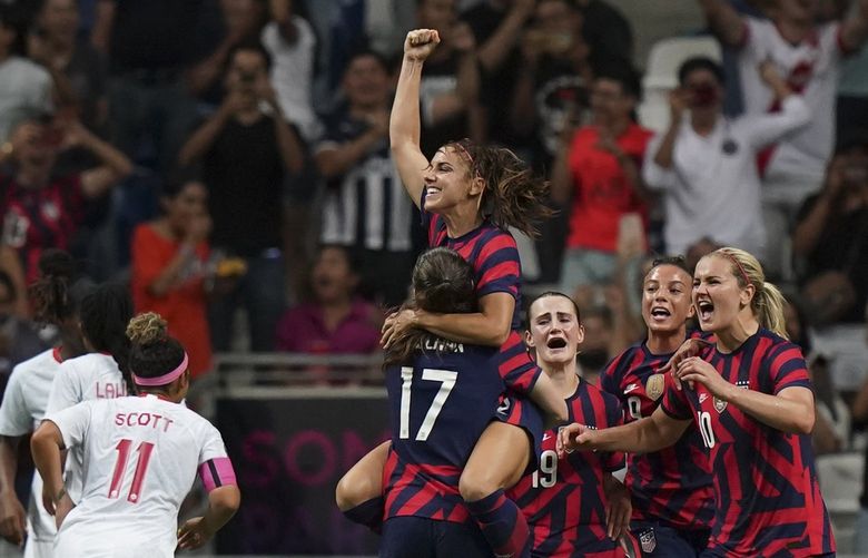United States’ Alex Morgan, top, is congratulated after scoring her side’s opening goal from the penalty spot against Canada during the CONCACAF Women’s Championship final soccer match in Monterrey, Mexico, Monday, July 18, 2022. (AP Photo/Fernando Llano) XMC182 XMC182