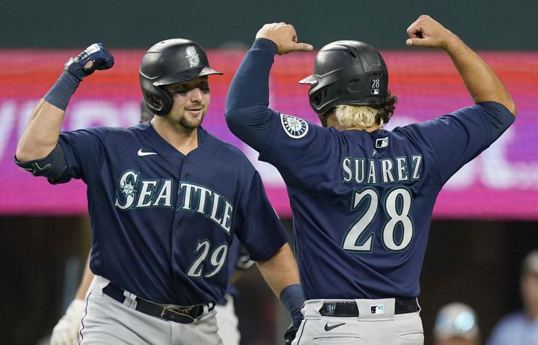 Seattle Mariners Cal Raleigh (29) flexes with teammate Eugenio Suarez (28) after Raleigh’s two run homer during the fourth inning of a baseball game against the Texas Rangers in Arlington, Texas, Sunday, July 17, 2022. (AP Photo/LM Otero) TXMO108 TXMO108