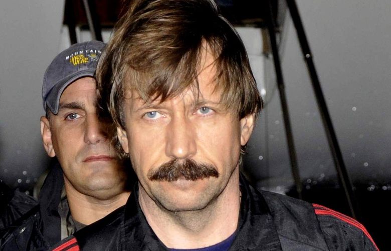 ** FOR USE AS DESIRED, YEAR END PHOTOS ** FILE – This Nov. 16, 2010 file photo provided by the Drug Enforcement Administration, shows Russian arms trafficking suspect Viktor Bout, center, in U.S. custody after being flown from Bangkok to New York in a chartered U.S. plane, extradited in manacles to face terrorism charges despite a final outraged push by Russian diplomats to persuade Thailand to release him. (AP Photo/Drug Enforcement Administration, File) NYYE148