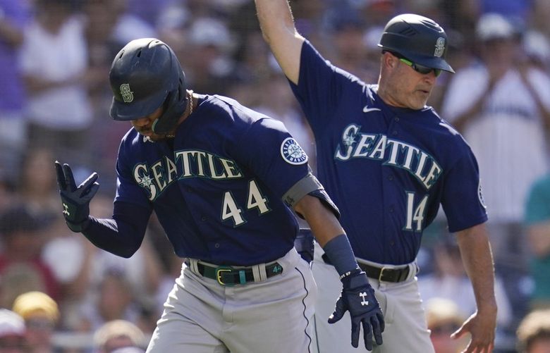 Seattle Mariners’ Julio Rodriguez, left, reacts with third base coach Manny Acta after hitting a two-run home run during the fourth inning of a baseball game against the San Diego Padres, Monday, July 4, 2022, in San Diego. (AP Photo/Gregory Bull) CAGB112 CAGB112