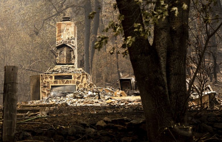 A chimney stands at a home destroyed by the McKinney Fire on Tuesday, Aug. 2, 2022, in Klamath National Forest, Calif. (AP Photo/Noah Berger) CANB109 CANB109