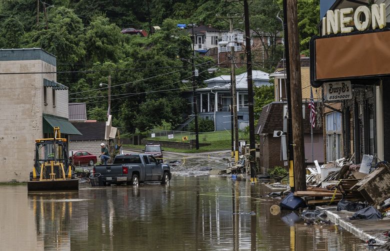 Work to clear debris from flooding on a street in Fleming-Neon, Ky., Aug. 1, 2022. Heavy rain was expected to produce more flooding across already-saturated eastern Kentucky on Monday, days after flash floods in the area killed at least 28 people and left dozens missing. (Jon Cherry/The New York Times) XNYT67 XNYT67