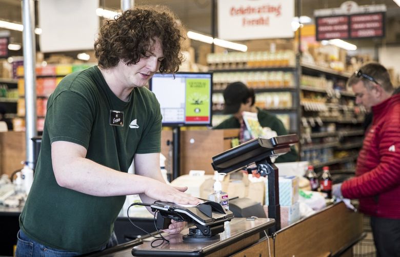Evan Fagan, employee of Central Market, disinfects the card reader before the next customer on Tuesday.  
The grocery chain plans to add staff to keep stores disinfected. 


On Tuesday, March 17, 2020. 213378