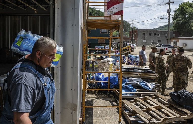 People unload goods from a truck into a supply area in flood-damaged Fleming-Neon, Ky., Aug. 2, 2022. The region, one of the poorest in the country, is full of modest, unprotected homes and decaying infrastructure. Some residents say they won’t return. (Jon Cherry/The New York Times)