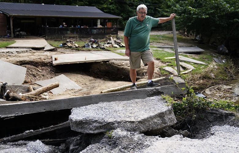 Douglas Maggard, 63, stands next to the bridge leading to his daughter home that was destroyed during massive flooding, on Thursday, Aug. 4, 2022, in Chavies, Ky. Maggard says he called his daughter and told her to leave right before the water rushed in destroying the bridge. (AP Photo/Brynn Anderson) KYBA115 KYBA115