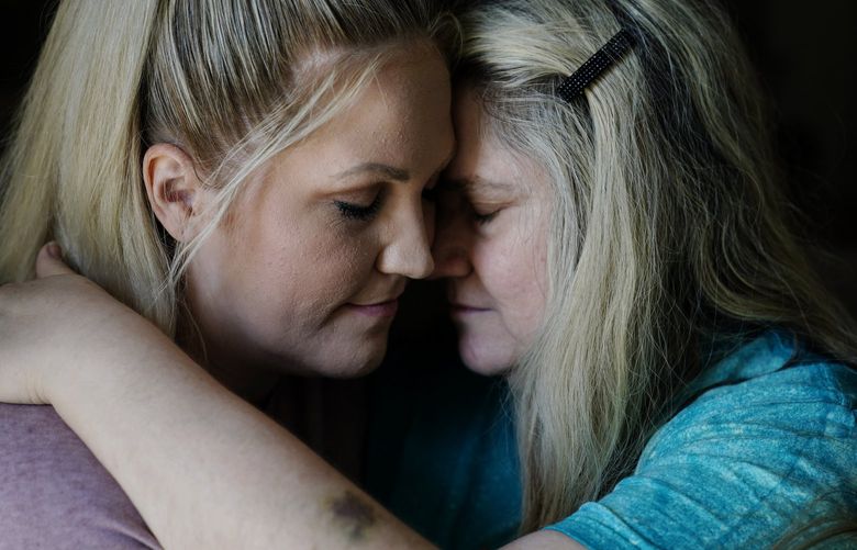 Angel Campbell, 37, left, embraces her mother Patricia Collins, 58, right, on Thursday, Aug. 4, 2022, in Chavies, Ky. Collins was badly injured in massive flooding. Campbell says they lost her grandmother in the same house as Collins. Campbell says that her mother and grandmother were both standing on a table as the water swept them both away. Collins survived with injuries while her mother Nellie Mae Howard, died in the flood. (AP Photo/Brynn Anderson) KYBA116 KYBA116