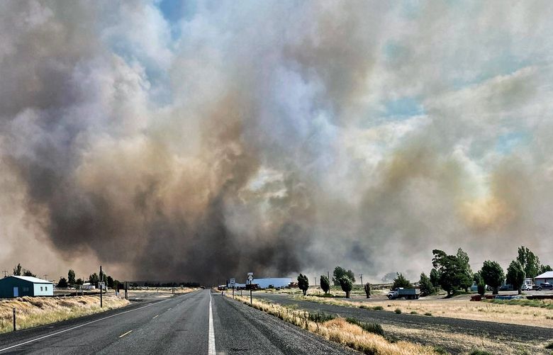 RETRANSMISSION TO CORRECT STATE – This photo provided by the Washington State Department of Transportation shows smoke from a wildfire burning south of Lind, Wash. on Thursday, Aug. 4, 2022. Sheriff’s officials are telling residents in the town of Lind in eastern Washington to evacuate because of a growing wildfire south of town that was burning homes. (Washington State Department of Transportation via AP) LA404 LA404