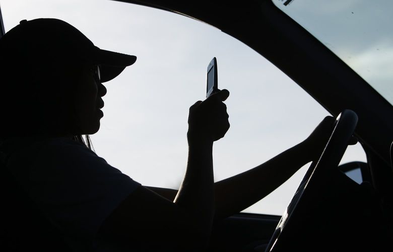 FILE – A driver uses a cell phone in Yarmouth, Maine, Sept. 8, 2009. New research indicates that state laws that are broadly worded to prohibit drivers from holding a cell phone under any circumstance appear to be effective in reducing rear-end crashes. The research paper, published by the Insurance Institute for Highway Safety on Tuesday, Aug. 9, 2022, looked at data from Oregon, Washington and California and compared it to Colorado and Idaho. (AP Photo/Robert F. Bukaty, File) NYSS302 NYSS302