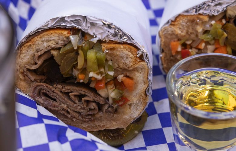 Smarty Pants’ Italian beef sandwich, in all its messy glory, with a Seattle Handshake: a glass of PBR and a shot of Malort, Monday, Aug. 8, 2022 in Seattle’s Georgetown neighborhood.