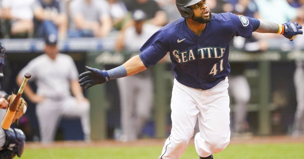 Seattle Mariners' Carlos Santana, left, and J.P. Crawford congratulate Ty  France, right, for hitting a three-run home run against the Los Angeles  Angels during the seventh inning of a baseball game in