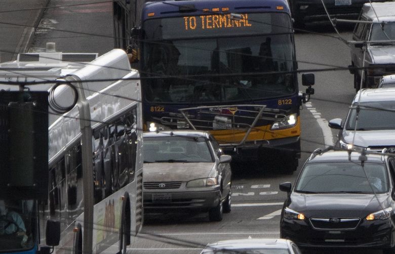 A car at left is sandwiched between two buses as its driver drives illegally in a BUS ONLY lane along 4th Ave. S. near S. Jackson St. in Seattle Wednesday, August 10, 2022.  Seattle traffic violations dropped 67% from 2019 to 2021, but it doesn’t mean we’re better drivers. SPD says it’s a staffing issue, and a matter of the department allocating limited resources

  221247