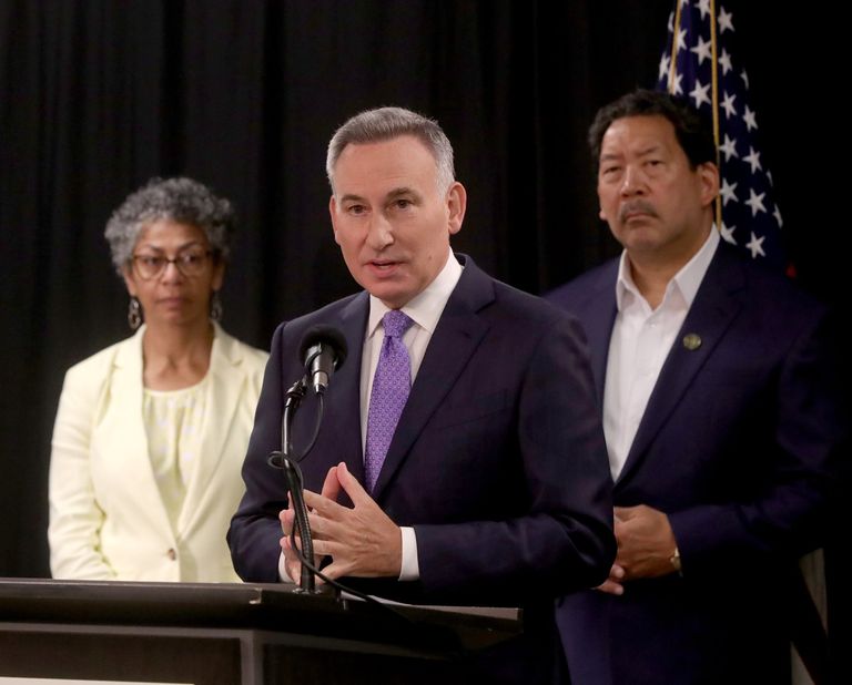 King County Executive Dow Constantine speaks to the media with Seattle Mayor Bruce Harrell and King County Sheriff Patti Cole-Tindall behind him