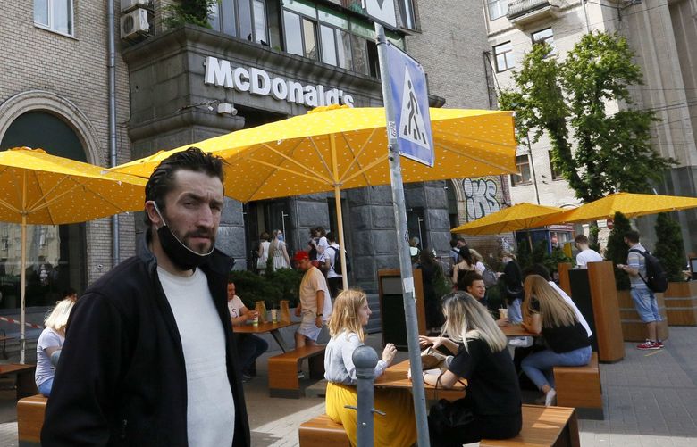 FILE – People, some of them still in masks to protect against coronavirus, enjoy outdoor McDonald’s meal in downtown Kyiv, Ukraine, on June 9, 2020. McDonald’s announced Thursday, Aug. 10, 2022, that the company will start reopening restaurants in Ukraine in the coming months, a symbol of the war-torn country’s return to some sense of normalcy and a show of support after the American fast-food chain pulled out of Russia. (AP Photo/Efrem Lukatsky, File) NYDD201 NYDD201