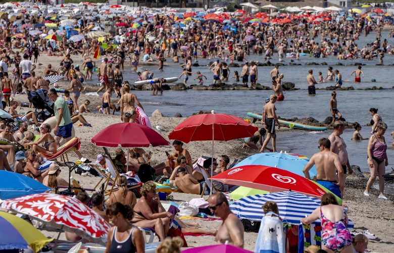 Vacationers spend a day at a crowded beach at the Baltic Sea in Timmendorfer Strand, Germany, Wednesday, Aug. 3, 2022. Germany expects high temperatures on Thursday. (AP Photo/Michael Probst)