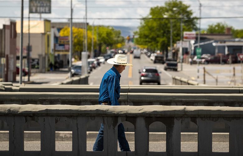 A man walks on a bridge above the Lewis Street underpass in downtown Pasco. Lewis Street goes under the railroad tracks that separate East Pasco from the rest of the city. The bridge created a physical barrier between the city’s segregated sections. As of March, plans to replace the 84-year-old Lewis Street underpass with a bridge are making progress after awarding a $22.3 million construction contract to Cascade Bridge, according to the Tri-City Herald. 

May 11, 2021