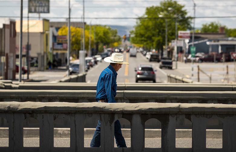 A man walks on a bridge above the Lewis Street underpass in downtown Pasco. Lewis Street goes under the railroad tracks that separate East Pasco from the rest of the city. The bridge created a physical barrier between the city’s segregated sections. As of March, plans to replace the 84-year-old Lewis Street underpass with a bridge are making progress after awarding a $22.3 million construction contract to Cascade Bridge, according to the Tri-City Herald.
May 11, 2021