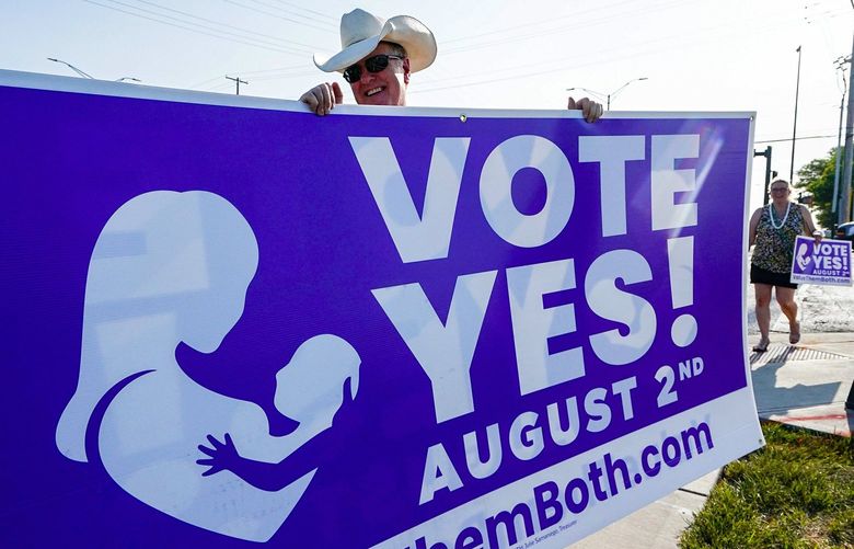 A supporter of the Vote Yes to a Constitutional Amendment on Abortion holds up a sign along 135th Street on Aug. 1, 2022, in Olathe, Kansas. (Kyle Rivas/Getty Images/TNS) 55921887W