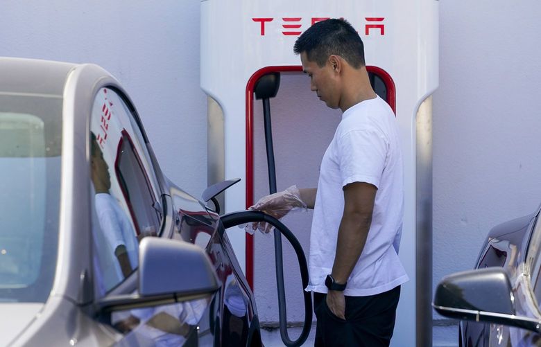 A man charges a Tesla at a charging station in Emeryville, Calif., Wednesday, Aug. 10, 2022. (AP Photo/Godofredo A. VÃ(degrees)squez) CAGV310 CAGV310