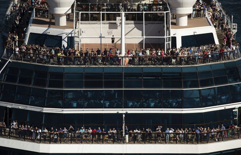 People stand on decks at the bow of the Celebrity Cruises vessel Celebrity Eclipse as it leaves port in Vancouver, British Columbia, for a trip to Alaska, Sunday, Aug. 14, 2022. (Darryl Dyck/The Canadian Press via AP) 