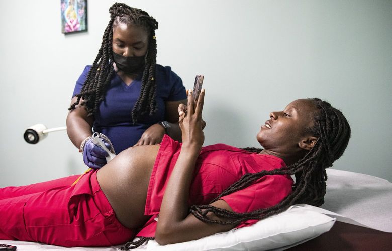 Audreanna Lewis, left, a nurse-midwife, examines D’Asia Newton during a prenatal visit at Sisters in Birth, a maternity clinic, in Jackson, Miss., July 21, 2022. The state that spurred the overturning of abortion rights is among 17 that have so far rejected a new option to extend new mothers’ Medicaid coverage for a year. (Ariel Cobbert/The New York Times) XNYT7 XNYT7
