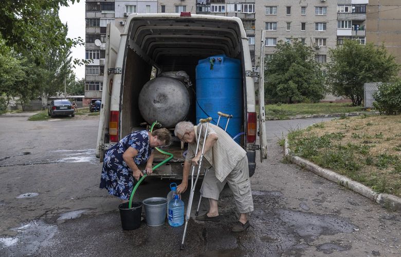 Residents receive drinking water from a truck brought by volunteers to Druzhkivka, Ukraine on Aug. 3, 2022. The area lacks running water and gas after months of Russian attacks. (David Guttenfelder/The New York Times) XNYT136 XNYT136