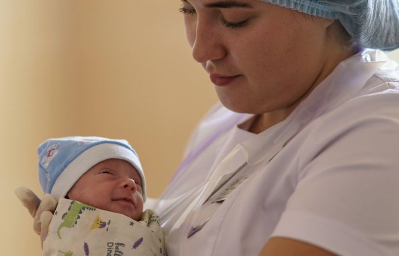 Alina Haupt, an intern-doctor, holds Veronika, a baby born prematurely at 29 weeks, at the Pokrovsk Perinatal Hospital in Pokrovsk, Donetsk region, eastern Ukraine, Monday, Aug. 15, 2022. Doctors say the stress caused by the war and rapidly worsening living conditions are leading to more frequent birth complications for the area’s pregnant women. (AP Photo/David Goldman) UKRDG507 UKRDG507