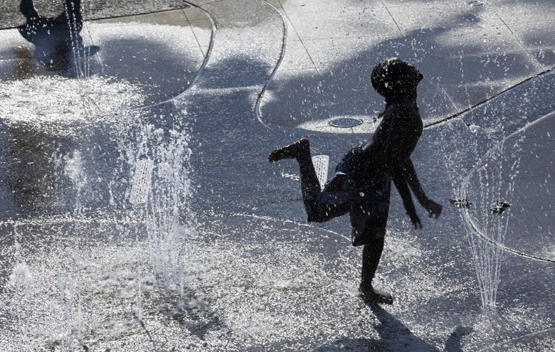Children cool off in the water park area at Jefferson Park in the Beacon Hill neighborhood of Seattle on Monday. Temperatures will be heating up as the week continues. A high of 88 is predicted for Thursday. (Ellen M. Banner / The Seattle Times)