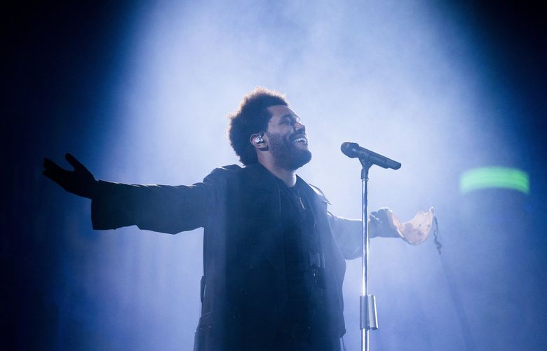 The Weeknd takes off his mask as he performs at Lumen Field on Aug. 25, 2022.