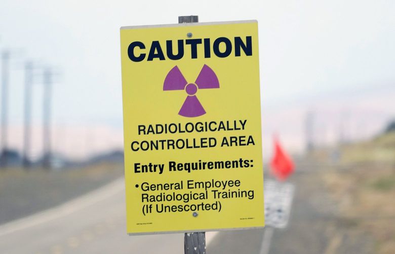 FILE – A caution sign is shown on a road on the Hanford Nuclear Reservation on June 2, 2022. A deal to address two nuclear waste storage tanks that are leaking radioactive materials into the soil on the reservation in Washington state has been reached between Washington state and the U.S. Department of Energy. (AP Photo/Ted S. Warren, File) FX411 FX411