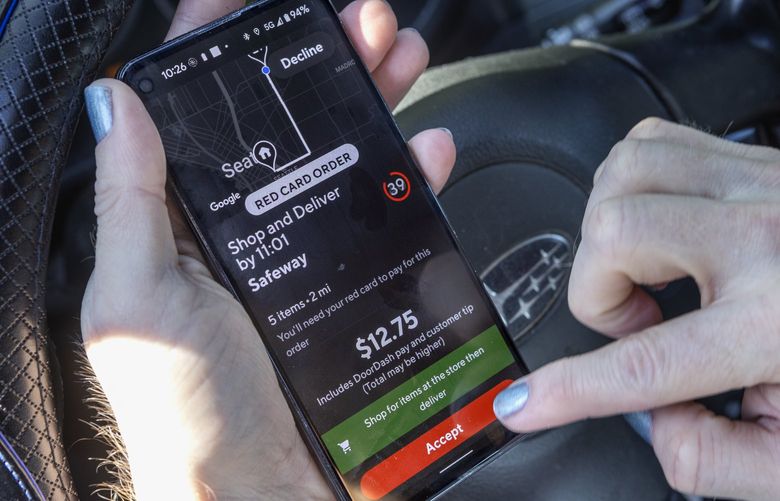 Maelstrom Pullman, a DoorDasher, accepts a request for a delivery on his phone Tuesday, August 30, 2022. The time to accept a request is very short, sometimes only 30 seconds.  Pullman lives in Capitol Hill and delivers in the Central Seattle area.  He’s been heavily involved in advocacy work for the Pay Up legislation that Seattle adopted this year (to go into effect next year) that would ensure a minimum wage and IRS reimbursement for delivery drivers.  221380