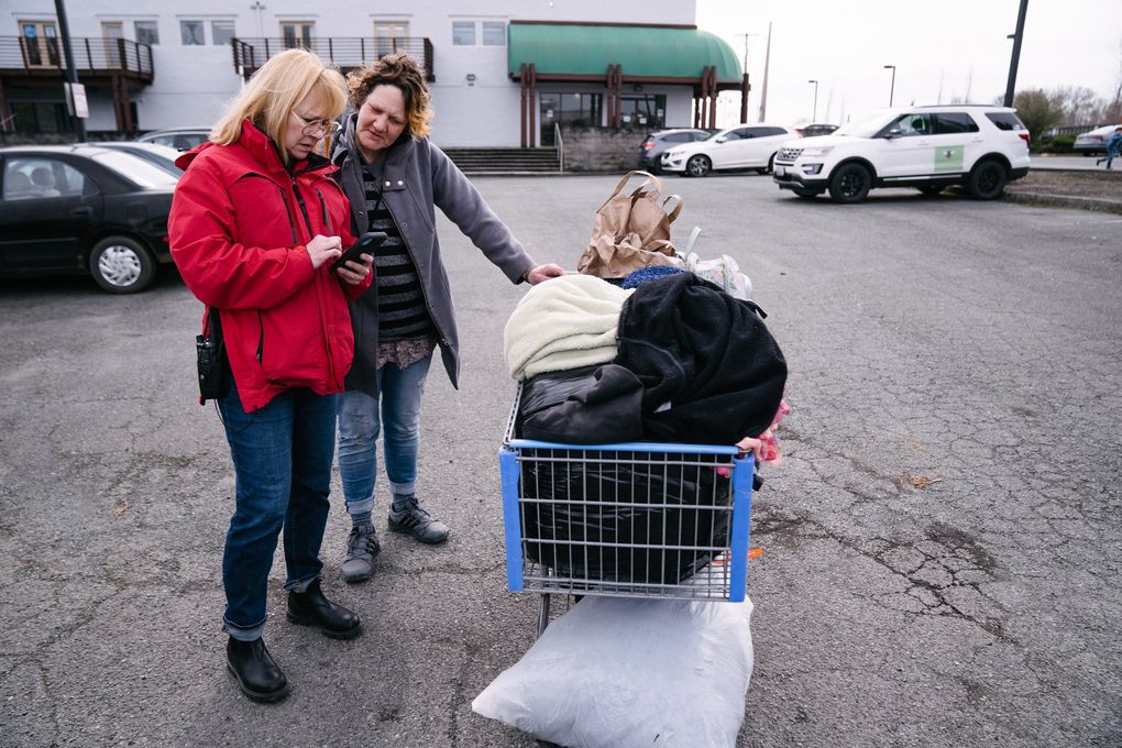 A social worker with the Mount Vernon Police Department, calls for a police vehicle to help transfer a woman’s belongings to secured shelter width=