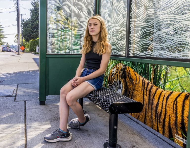 Addie Trask sits at a bus stop in Seattle