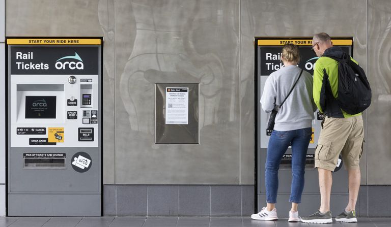 Two people buy tickets to ride light rail at Sound Transit’s Tukwila International Boulevard Station