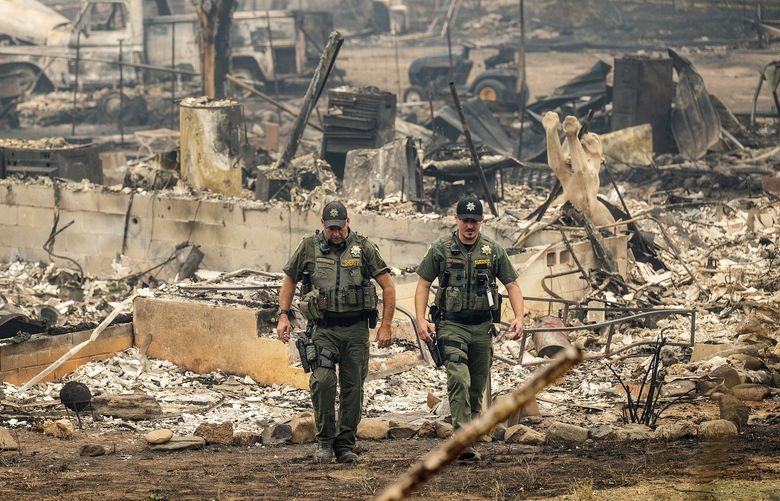 Sheriff’s deputies leave a home where a McKinney Fire victim was found on Monday, Aug. 1, 2022, in Klamath National Forest, Calif. (AP Photo/Noah Berger) CANB112 CANB112