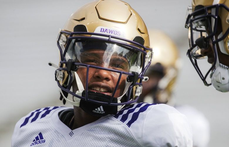 Cornerback Davon Banks (10) speaks with a teammate on Day 5 of the University of Washington football training camp at Husky Stadium in Seattle on August 9, 2022. 221188