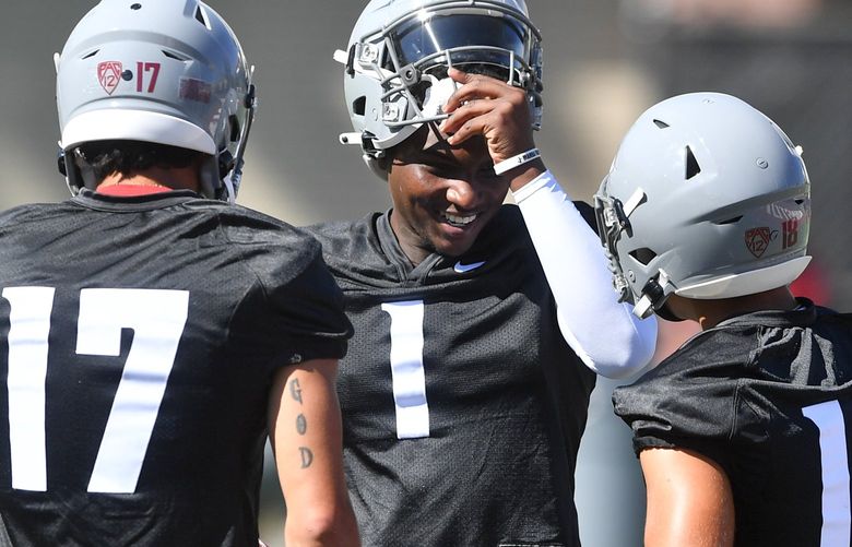 WSU quarterback Cameron Ward (1) laughs with his fellow quarterbacks during a college football practice on Wednesday, Aug. 3, 2022, at WSU’s practice facility in Pullman, Wash.