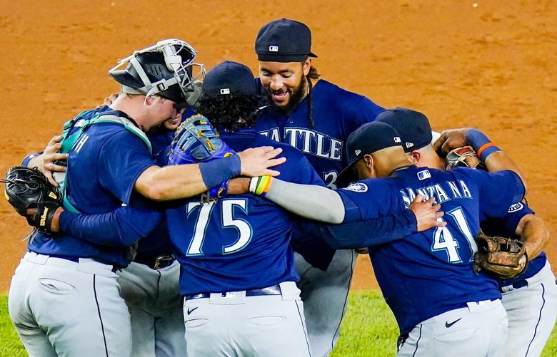 Seattle Mariners relief pitcher Andres Munoz (75), Carlos Santana (41) and J.P. Crawford celebrate with teammates after a baseball game against the New York Yankees Tuesday, Aug. 2, 2022, in New York. The Mariners won 8-6. (AP Photo/Frank Franklin II) NYY128