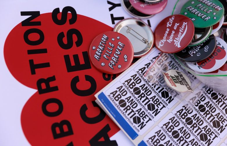 Buttons and signs are stacked during the Shout Your Abortion (SYA) gathering to protest the U.S. Supreme Court decision overturning Row v. Wade at Yesler Terrace Park in Seattle Friday, June 24, 2022. 220807